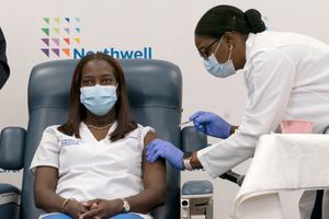 FILE – Sandra Lindsay, left, a nurse at Long Island Jewish Medical Center, is inoculated with the Pfizer-BioNTech COVID-19 vaccine by Dr. Michelle Chester, Monday, Dec. 14, 2020, in the Queens borough of New York. Lindsay has appeared on panels, Zoom town halls and at other events in the United States and in Jamaica, her homeland, promoting vaccination and addressing questions, fears and misconceptions from the public. (AP Photo/Mark Lennihan, Pool, File)