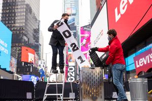 Jonathan Bennett, host of Good Riddance Day, left, and Joe Papa, Director of Events, Times Square Alliance burn a 2021 banner at the official Good Riddance Day celebration in Times Square on Tuesday in New York. (AP Photo/Corey Sipkin)