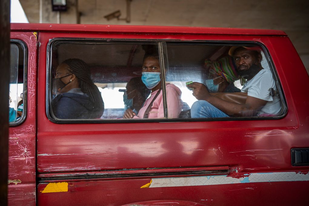 Passengers, some wearing masks, wait for their taxi to leave the Baragwanath taxi rank in Soweto, South Africa, Thursday Dec. 2, 2021. South Africa launched an accelerated vaccination campaign to combat a dramatic rise in confirmed cases of COVID-19 a week after the omicron variant was detected in the country. (AP Photo/Jerome Delay)