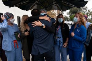 2021 年 12 月 9 日星期四，在加利福尼亚州 Mission Viejo 的普罗维登斯教会医院，注册护士 Lisa Lampkin（中心）面对镜头拥抱她的前 COVID-19 患者 Brian Patnoe，前冠状病毒患者及其护理人员聚集在一起庆祝医院成立 50 周年。 在人们对这种已经席卷全球的病毒知之甚少的时候，挽救了他们生命的病人和护士、呼吸治疗师和医生是一次情感重聚。 （美联社照片/Jae C. Hong）