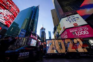 FILE – The 2022 sign that will be lit on top of a building on New Year’s Eve is displayed in Times Square, New York, Monday, Dec. 20, 2021. Revelers will still ring in the new year in New York’s Times Square next week, there just won’t be as many of them as usual under new restrictions announced Thursday, Dec. 23, 2021, as the city grapples with a spike in COVID-19 cases. (AP Photo/Seth Wenig, File)