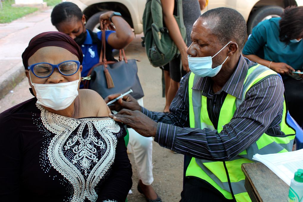 A woman receives a coronavirus vaccine in Abuja, Nigeria on Monday. A pandemic-weary world faces weeks of confusing uncertainty as countries restrict travel and take other steps to halt the newest potentially risky coronavirus mutant before anyone knows just how dangerous omicron really is. (Gbemiga Olamikan / AP, file)