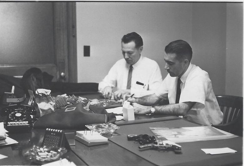 Ralph Himmelsbach, left, worked for the FBI for 20 years before the D.B. Cooper case. Here, he helps count recovered bank loot in 1962 at the Portland office. (Courtesy Himmelsbach family) 