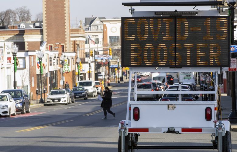 FILE – A sign promotes booster shots outside a COVID-19 vaccination site in Revere, Mass., on Dec. 21, 2021. The Centers for Disease Control and Prevention recommended on Tuesday, Jan. 4, 2022, that Americans who received two doses of the Pfizer-BioNTech coronavirus vaccine seek a booster shot five months after the second shot, and not wait six months, as earlier guidance had said. (M. Scott Brauer/The New York Times) XNYT153 XNYT153