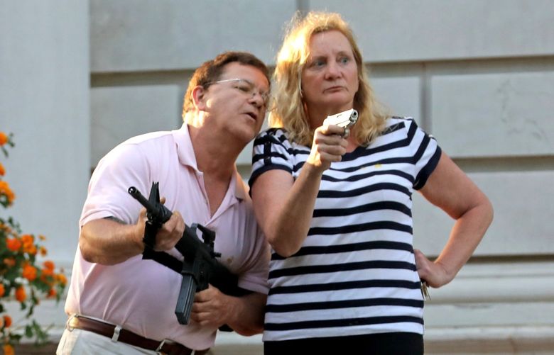 FILE – In this June 28, 2020 file photo, armed homeowners Mark and Patricia McCloskey, stand in front their house confronting protesters marching to St. Louis Mayor Lyda Krewson’s house in the Central West End of St. Louis. The City Counselor’s Office told a judge during a virtual hearing Wednesday, Jan. 5, 2022, that the guns taken from the McCloskeys have not been disposed of. The McCloskeys pleaded guilty to misdemeanors last year and were ordered to forfeit the guns. Mark McCloskey’s lawsuit says a subsequent pardon from Republican Gov. Mike Parson means they should get their weapons back. The city disagrees. (Laurie Skrivan/St. Louis Post-Dispatch via AP, File) MOSTP215 MOSTP215