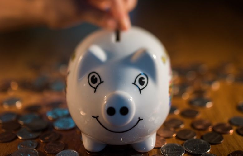 A coin is dropped into a piggy bank. Photographer: Ron Antonelli/Bloomberg