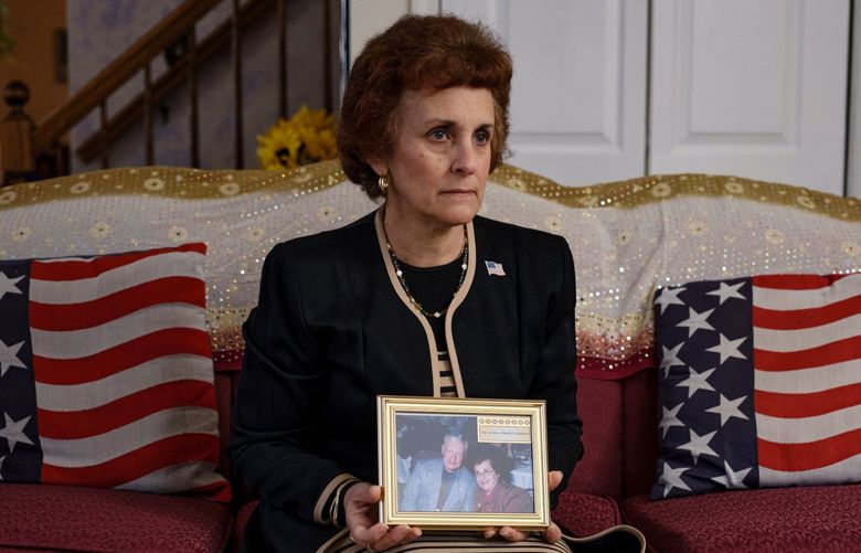 Regina Costantino Discenza holds a photo of her parents, Madeline and Charles Costantino, at her home in Forked River, N.J., on Jan. 4, 2022. The Costantinos were among the 101 residents of a state-run nursing home for former soldiers who died as the coronavirus swept through the New Jersey facility.  (Stephen Speranza/The New York Times)