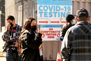 1 月 4 日，一名支持人员（左二）指导洛杉矶联合学区的学生和工作人员在洛杉矶 El Sereno 社区的一个步行站点排队等待 COVID-19 测试。（Genaro Molina / Los洛杉矶时报 / TNS)