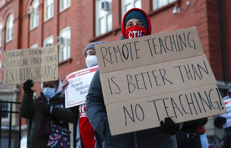 Members of the Chicago Teachers Union listen to speakers at a press conference outside of John Spry Community School in Chicago’s Little Village neighborhood on Jan. 10, 2022. (Jose M. Osorio/Chicago Tribune/TNS) 37162293W 37162293W