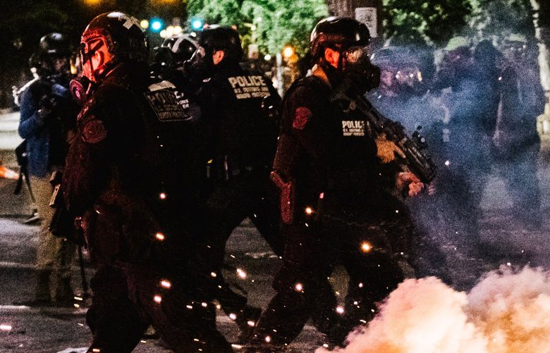 Federal officers in Portland, Ore., late Wednesday, July 29, 2020. Oregon’s governor, Kate Brown on Wednesday, announced that the federal law enforcement agents guarding the federal courthouse in downtown Portland would begin withdrawing as early as Thursday. (Brandon Bell/The New York Times)