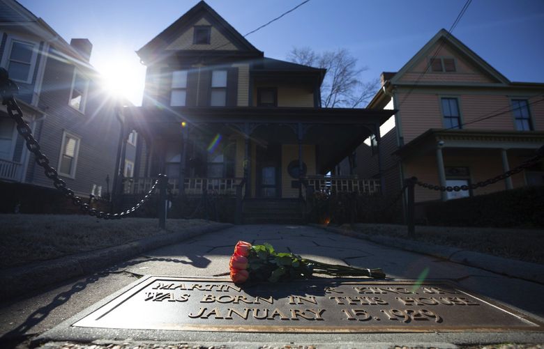 FILE – Flowers lay in front of the birthplace of Dr. Martin Luther King, Jr., on Jan. 18, 2021, in Atlanta. The annual Martin Luther King Jr. service is set to be held at his old congregation in Atlanta. (AP Photo/Branden Camp, File) TKMY104 TKMY104
