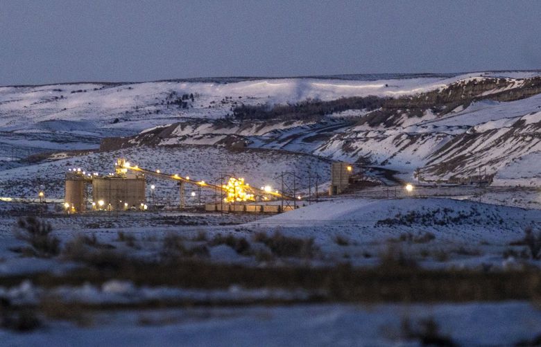 Lights illuminate a coal mine at twilight, Thursday, Jan. 13, 2022, in Kemmerer, Wyo. With the nearby coal-fired Naughton Powerplant being decommissioned in 2025, the fate of the coal mine and its workers is uncertain. (AP Photo/Natalie Behring) WYNB310 WYNB310
