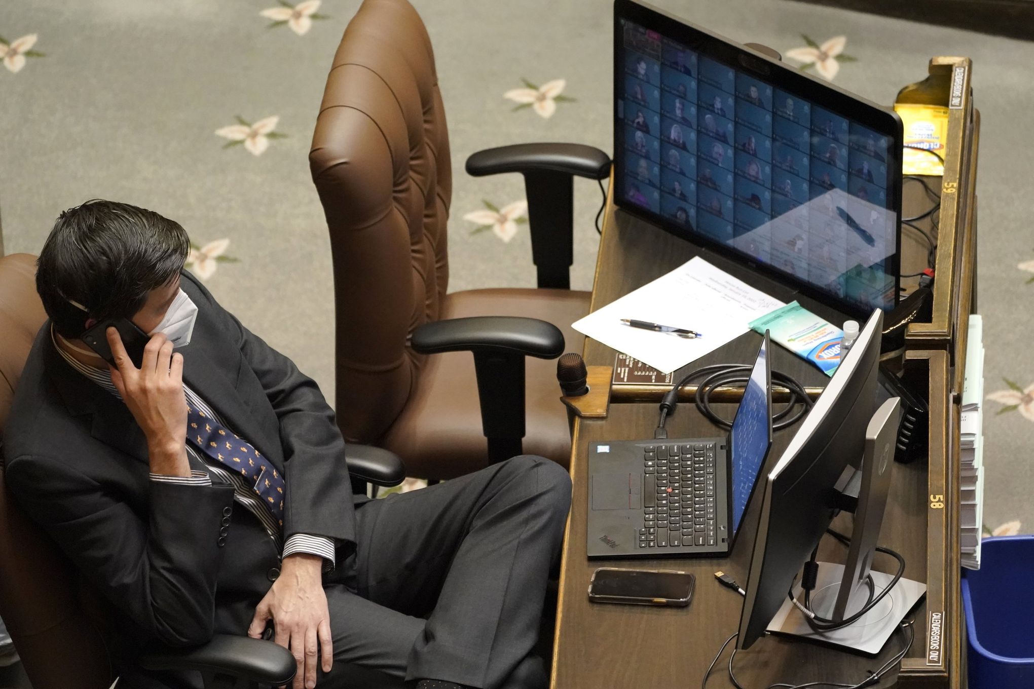 State Rep. Alex Ramel sitting at a desk on the phone in the House