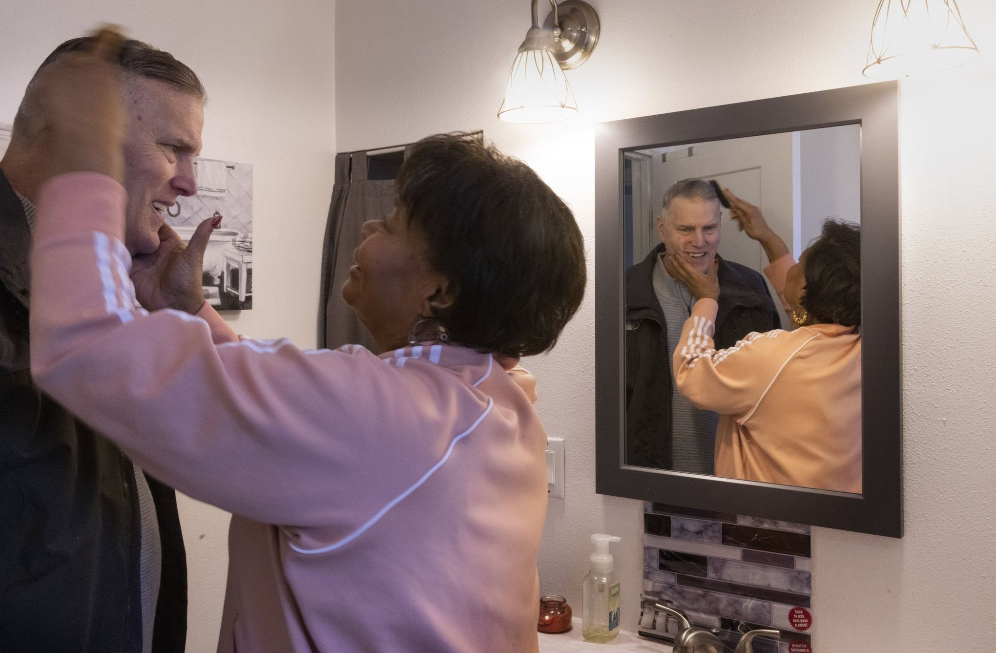 Angela Petersen combs her husband Chris’ hair at their home.