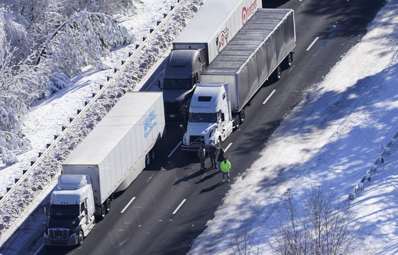 Drivers look down the roadway as cars and trucks are stranded on sections of Interstate 95 Tuesday Jan. 4, 2022, in Carmel Church, Va. Close to 48 miles of the Interstate was closed due to ice and snow. (AP Photo/Steve Helber) VASH110 VASH110