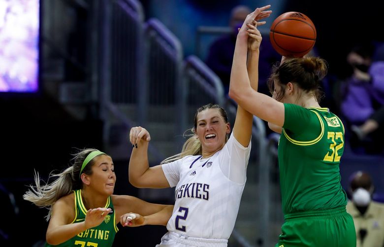 Washington Huskies forward Lauren Schwartz tries to go for the steal as Oregon Ducks guard Sydney Parrish, left, passes the ball to forward Sedona Prince during the second quarter.

 Friday, Jan. 21, 2022 in Seattle, Wash. 219370