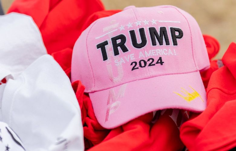 **EMBARGO: No electronic distribution, Web posting or street sales before 3:01 a.m. ET SUNDAY, SUNDAY, JAN. 23, 2022. No exceptions for any reasons. EMBARGO set by source.**A Trump hat for sale at a rally for former President Donald Trump in Florence, Ariz., Jan. 15, 2022. To many of those who attended the Trump rally but who never breached the Capitol, that date wasnâ€™t a dark day for the nation. It was a new start. (Stephen Goldstein/The New York Times) XNYT77