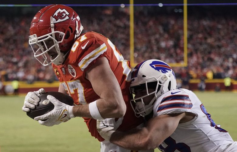 Kansas City Chiefs tight end Travis Kelce (87) catches an 8-yard touchdown pass over Buffalo Bills outside linebacker Matt Milano (58) during overtime in an NFL divisional round playoff football game, Sunday, Jan. 23, 2022, in Kansas City, Mo. The Chiefs won 42-36. (AP Photo/Charlie Riedel) MOCN215 MOCN215