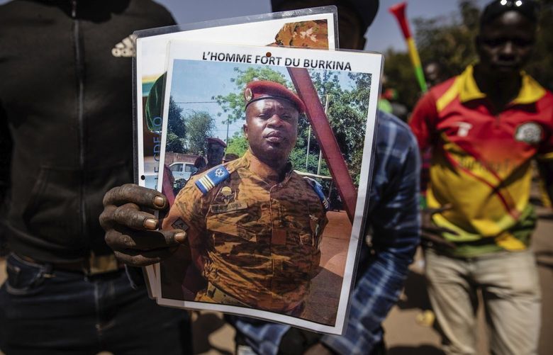 A man holds a portait of Lt. Col. Paul Henri Sandaogo Damiba who has taken the reins of the country in Ouagadougou Tuesday Jan. 25, 2022. people took to the streets in Burkina Faso to rally in support of the new military junta that ousted democratically elected President Roch Marc Christian Kabore and seized control of the country.(AP Photo/Sophie Garcia) OUA101 OUA101