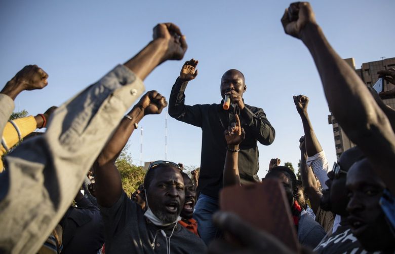 Activist Mamadou Drabo, leader of the Save Burkina Faso movement, announces to the crowd gathered Place de la Nation that Lt. Col. Paul Henri Sandaogo Damiba has taken the reins of the country in Ouagadougou Monday Jan. 24, 2022. More than a dozen mutinous soldiers declared Monday on state television that a military junta now controls Burkina Faso after they detained the democratically elected president following a day of gun battles in the capital. (AP Photo/Sophie Garcia) OUA108 OUA108