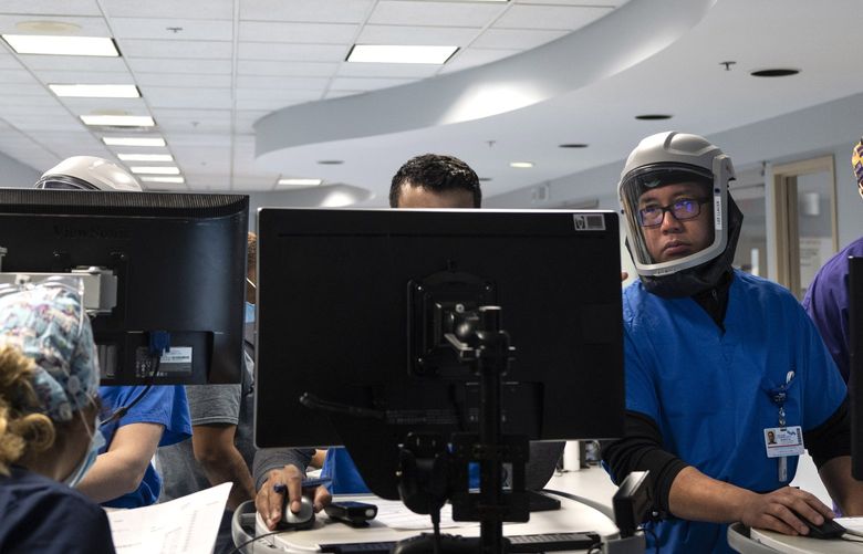 Doctors and other medical staffers make rounds in the ICU at Luminis Health Doctors Community Hospital in Lanham, Md., on Jan. 14, 2022. MUST CREDIT: Washington Post photo by Michael Robinson Chavez