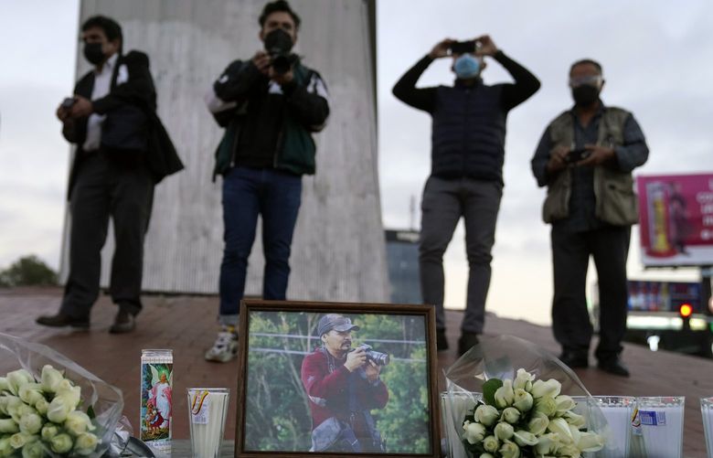 Journalists cover a vigil in honor of news photographer Margarito Martinez, pictured, Friday, Jan. 21, 2022, in Tijuana, Mexico. Martinez, a Tijuana-based photojournalist who specialized in covering gritty crime scenes in this border city, was shot as he left his home on Jan 17. (AP Photo/Gregory Bull) CAGB103 CAGB103