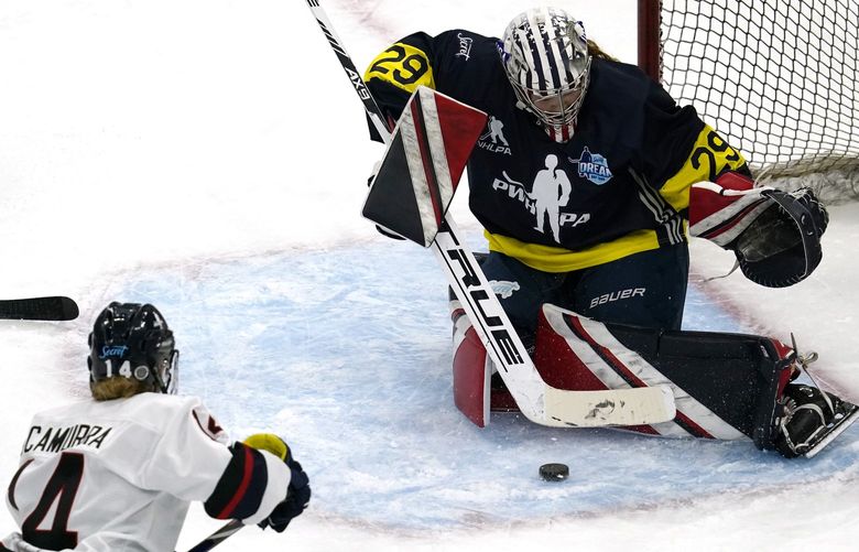 Team Adidas Minnesota goalie Nicole Hensley, right, makes a save on a shot by Women’s Sports Foundation New Hampshire’s Hayley Scamurra during the third period of the Dream Gap Tour hockey game at the United Center in Chicago, Saturday, March 6, 2021. (AP Photo/Nam Y. Huh)