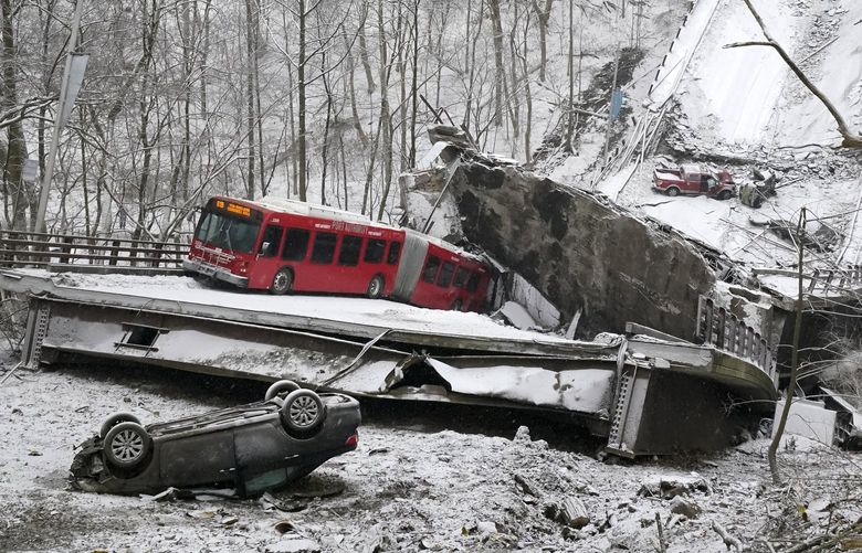A Port Authority bus that was on a bridge when it collapsed Friday Jan. 28, 2022, is visible in Pittsburgh’s East End.  A two-lane bridge collapsed in Pittsburgh early Friday, prompting rescuers to rappel nearly 150 feet (46 meters) while others formed a human chain to help rescue multiple people from a dangling bus.(AP Photo/Gene J. Puskar) PAKS102 PAKS102