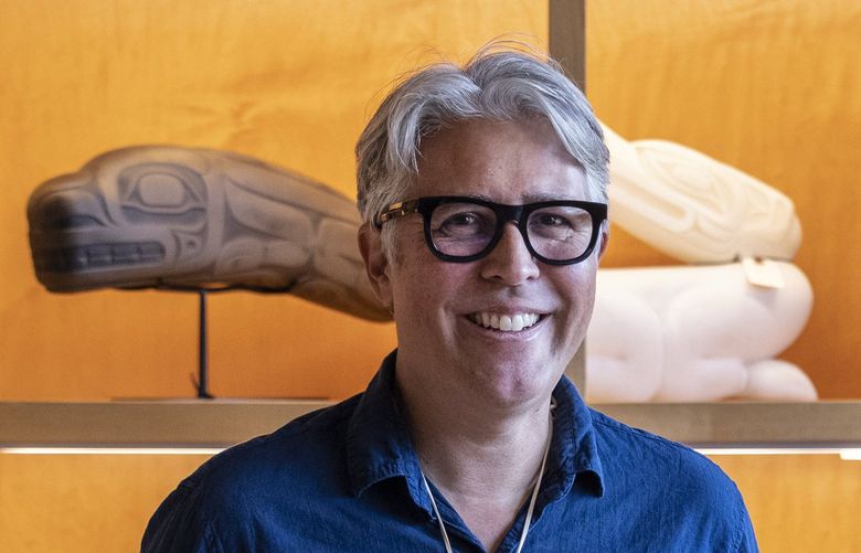 Friday, January 21, 2022.    Seattle glass artist Preston Singletary has a solo exhibit opening January 28, at the Smithsonian’s National Museum of the American Indian.  He’s photographed at his studio surrounded by many pieces of his work.    219386