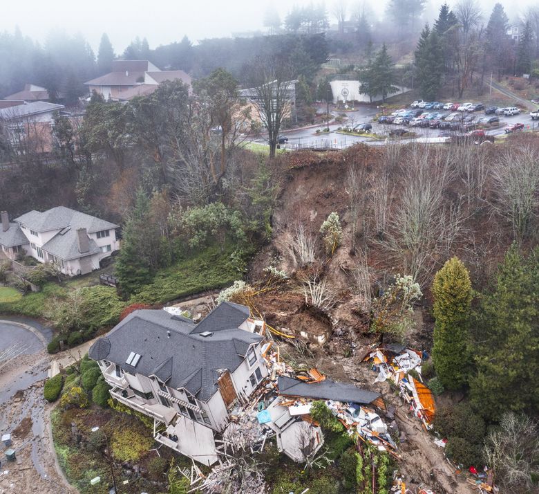 An aerial look shows the hillside where a Bellevue home slid off its foundation early Monday. Forest Ridge School’s parking lot is above the home. (Steve Ringman / The Seattle Times)