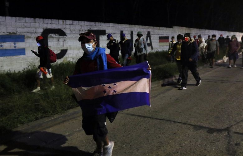 Members of a migrant caravan begin their journey in the hopes of reaching the United States, in San Pedro Sula, Honduras, Saturday, Jan. 15, 2022. (AP Photo/Delmer Martinez) XGR103 XGR103