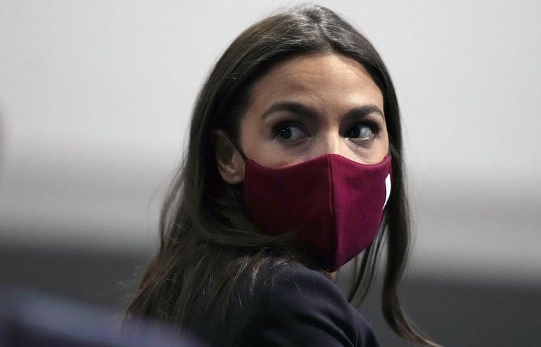 FILE – U.S. Rep. Alexandria Ocasio-Cortez looks round to listen to a question at the COP26 U.N. Climate Summit, in Glasgow, Scotland, Wednesday, Nov. 10, 2021. Ocasio-Cortez has tested positive for COVID-19 and â€œis experiencing symptoms and recovering at home,â€ her office said in a statement Sunday, Jan. 9, 2022. (AP Photo/Alastair Grant, File) NYSB705 NYSB705