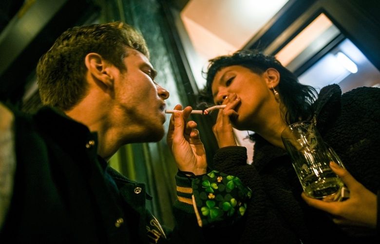 People smoke outside of a bar in New York, Dec. 17, 2021. Cigarettes, once shunned, have made a comeback with a younger crowd who knows better. (Dolly Faibyshev/The New York Times) XNYT60 XNYT60