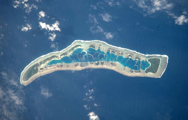 This image provided by NASA Tuesday July 14, 2009 shows Millennium Island photographed by an Expedition 20 crew member on the International Space Station July 1, 2009. Millennium Island is located at the southern end of the Line Islands in the South Pacific Ocean. This uninhabited island is part of the Republic of Kiribati, an island nation comprised of 32 atolls (including Millennium Island) and one raised coral island. Millennium Island is formed from a number of smaller islets built on coral reefs. The coral reefs grew around a now-submerged volcanic peak, leaving a ring of coral around an inner lagoon. The islands above the waterline are composed primarily of limestone rock and sand derived from the reefs. At a maximum height of approximately 6 m above sea level, Millennium Island has been identified as being at great risk from sea level rise by the United Nations. The islets of Millennium Island are readily visible in this photograph as irregular green vegetated areas surrounding the inner lagoon. The shallow lagoon waters are a lighter blue than the deeper surrounding ocean water; tan linear “fingers” within the lagoon are the tops of corals. The island has been recommended as both a World Heritage site and Biosphere Reserve. (AP Photo/NASA) NY111
