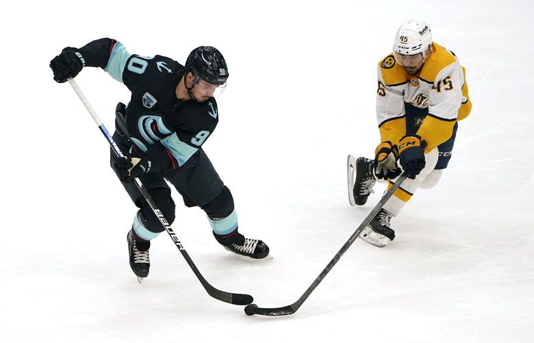 Seattle Kraken’s Marcus Johansson (90) and Nashville Predators’ Alexandre Carrier chase the puck in the first period of an NHL hockey game Tuesday, Jan. 25, 2022, in Seattle. (AP Photo/Elaine Thompson) WAET111 WAET111