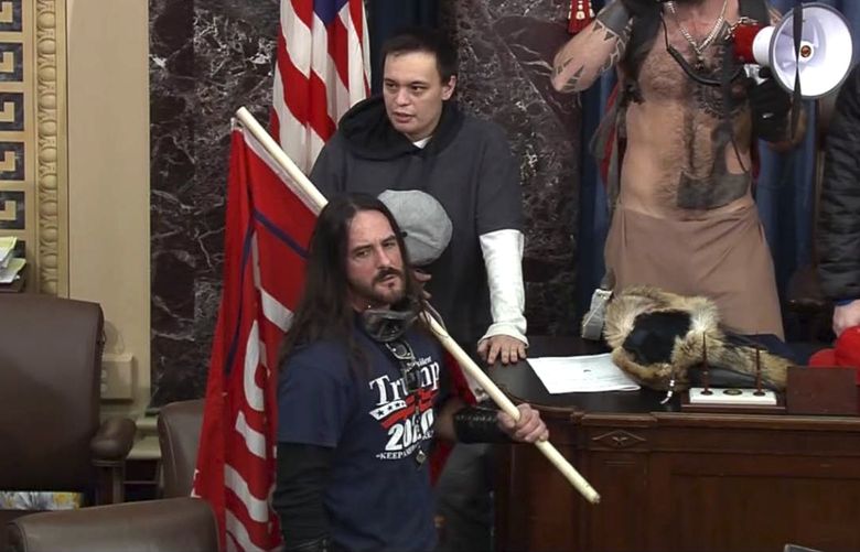 In this image from Senate Television video, Paul Allard Hodgkins, 38, of Tampa, Fla., front, stands in the well on the floor of the U.S. Senate on Jan. 6, 2021, at the Capitol in Washington. Hodgkins’ attorney wrote in part, “This country has a long history of the public seeking to punish those who are perceived to have done wrong in ‘their’ eyes. …. A significant percentage of our population will ‘cancel’ Mr. Hodgkins because of 15-minutes of bad judgment, casting stones in his directions, all the while never fully realizing their own indiscretions and hypocrisy.” (Senate Television via AP) DCJE836 DCJE836