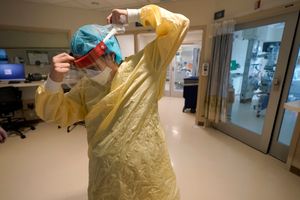 FILE – Registered nurse Sara Nystrom, of Townshend, Vt., prepares to enter a patient’s room in the COVID-19 Intensive Care Unit at Dartmouth-Hitchcock Medical Center, in Lebanon, N.H., Jan. 3, 2022. The omicron variant has caused a surge of new cases of COVID-19 in the U.S. and many hospitals are not only swamped with cases but severely shorthanded because of so many employees out with COVID-19. (AP Photo/Steven Senne, File)