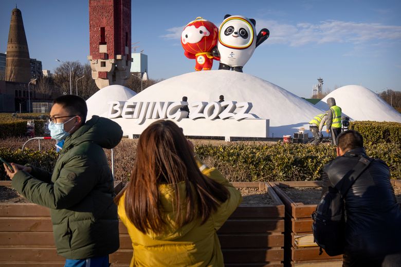 2022 年 1 月 12 日，星期三，在北京奥林匹克公园附近，人们戴着口罩以帮助预防冠状病毒，观看冬残奥会吉祥物 Shuey Rhon Rhon（左）和冬奥会吉祥物 Bing Dwen Dwen 的展示。就在几周前举办北京冬奥会，中国正在与六个城市的多起冠状病毒爆发作斗争，其中离首都最近的一个城市是由高度传播的 omicron 变种驱动的。 （美联社照片/马克 Schiefelbein）