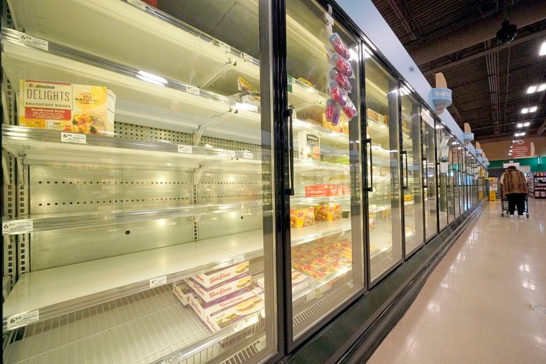 2022 年 1 月 11 日，星期二，一位购物者在宾夕法尼亚州蔓越莓镇的一家杂货店里走过部分空的冷冻食品冷藏箱。最近几周，美国杂货店的短缺情况随着新问题的增加而增加——比如快速传播的 omicron 变体和恶劣的天气——自冠状病毒大流行开始以来一直困扰零售商的供应链斗争和劳动力短缺加剧。 （美联社照片/Gene J. Puskar）