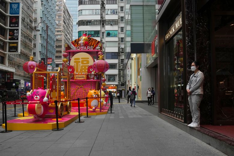 2022 年 1 月 28 日,星期五,一名戴着口罩的店员在香港的一家商店等候顾客。香港正在将来自海外的人的强制隔离时间从 21 天缩短到 14 天,即使南方中国城市与新的 COVID-19 病例激增作斗争。 (美联社照片/Kin Cheung)