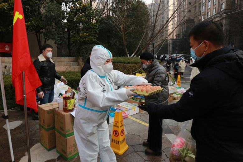 2022 年 1 月 3 日星期一,一名社区志愿者将鸡蛋交给一家临时食品店的买家,为中国西北部陕西省西安市一个居民区外的居民提供物资。中国北方城市西安当局有人说,在近两周的封锁期间,他们可以为大约 1300 万人提供食物、医疗保健和其他必需品。 但一些居民描述了获得物资的困难和沮丧,以及对这座著名兵马俑和主要工业所在地的经济影响。 (Chinatopix Via AP)