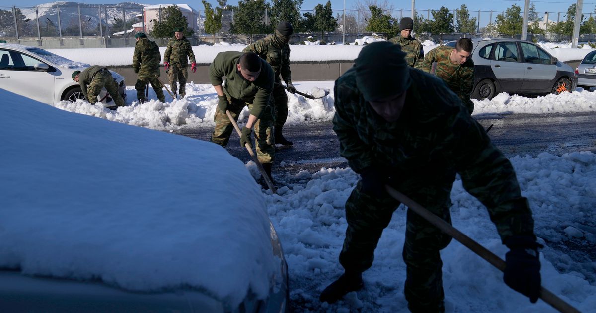 Tentara Yunani membantu memindahkan kendaraan di jalan yang dilanda salju