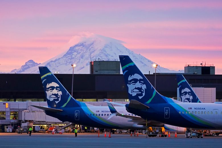 阿拉斯加航空公司周四宣布，由于人员短缺，它将在 1 月底之前削减 10% 的航班。 上图，3 月 1 日在西雅图的西雅图-塔科马国际机场，飞机停在门口，背景是雷尼尔山。 （泰德·S·沃伦，美联社）