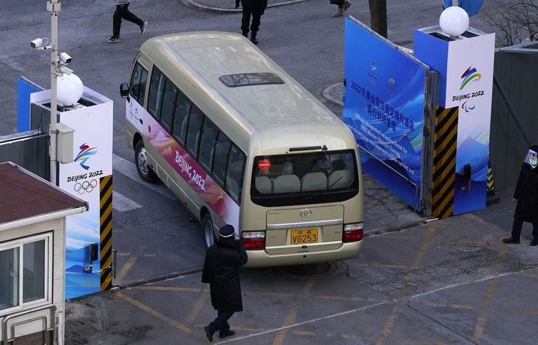 A bus is allowed through a security gate at a hotel inside the Olympic bubble at the 2022 Winter Olympics, Monday, Jan. 31, 2022, in Beijing. (AP Photo/Mark Humphrey) OLYMH101 OLYMH101