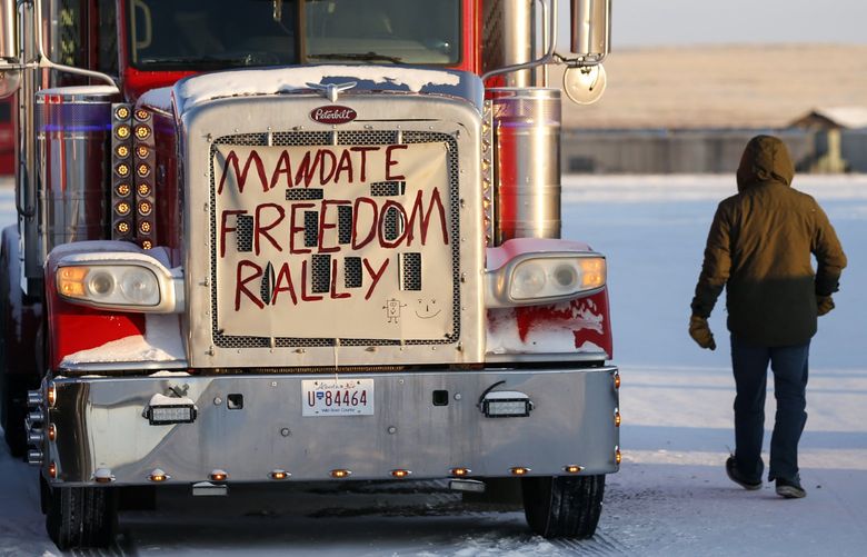 A truck convoy of anti-COVID-19 vaccine mandate demonstrators continue to block the highway at the busy U.S. border crossing in Coutts, Alta., Wednesday, Feb. 2, 2022. (Jeff McIntosh /The Canadian Press via AP) JMC106 JMC106