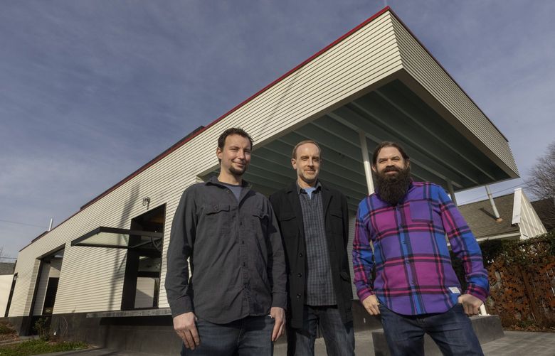 L – R — Zac Culler, John Sutton and Ben Beres — perhaps better known as the trio SuttonBeresCuller — stand in front of the new Mini Mart City Park building located at 6525 Ellis Ave S. In Seattle Friday, January 28, 2022. The three have worked for the past 15 years to try to turn a former gas station in Georgetown into an arts space/pocket park. It had its first soft opening last Saturday, will continue to have those on future Saturdays from 12 – 5 and then will fully open in early spring. The building will be a flex space and will be a blank canvas, used for community events, art shows, exhibitions and will have a roll-down screen where visitors can watch movies. 219431