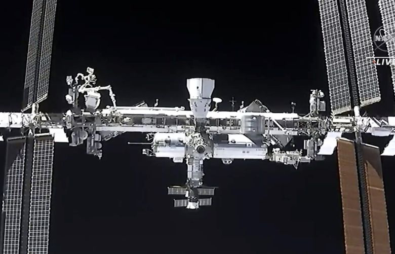 FILE – This image made from NASA TV shows the international space station, seen from the SpaceX Crew Dragon spacecraft Saturday, April 24, 2021. NASA called off a spacewalk Tuesday, Nov. 30, because of menacing space junk that could puncture an astronaut’s suit or damage the International Space Station. Two U.S. astronauts were set to replace a bad antenna outside of the space station. But late Monday night, Mission Control was notified that a piece of orbiting debris might come dangerously close. (NASA via AP, File)
