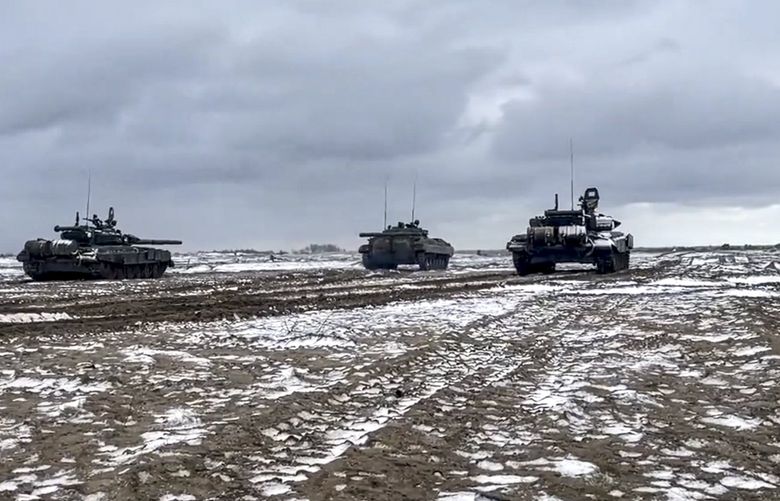 In this photo taken from video and released by the Russian Defense Ministry Press Service on Wednesday, Feb. 2, 2022, Russian and Belarusian tanks drive during a joint military drills at Brestsky firing range, Belarus. Russian and Belarus troops held joint combat training at firing ranges in Belarus Wednesday as tensions remain high under the looming threat of war with Ukraine. The drills involved motorized rifle, artillery and anti-tank missile units, as well tanks’ and armoured personnel carriers’ crews. (Russian Defense Ministry Press Service via AP) XAZ105 XAZ105