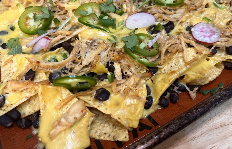 With chicken breast cooked in broth and a homemade queso recipe, these pulled chicken nachos make a perfect Superbowl party snack without skimping on quality.
