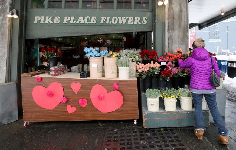 Pike Place Flowers is a bright spot at Pike Place Market the day before Valentine’s Day, Feb. 13, 2021. (Alan Berner / The Seattle Times)